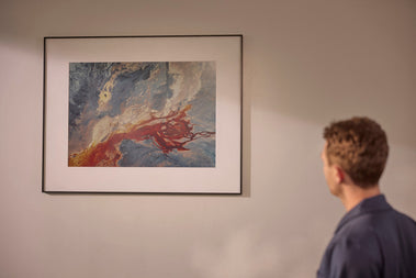 Man viewing an abstract artwork displayed on an InkPoster color ePaper art poster